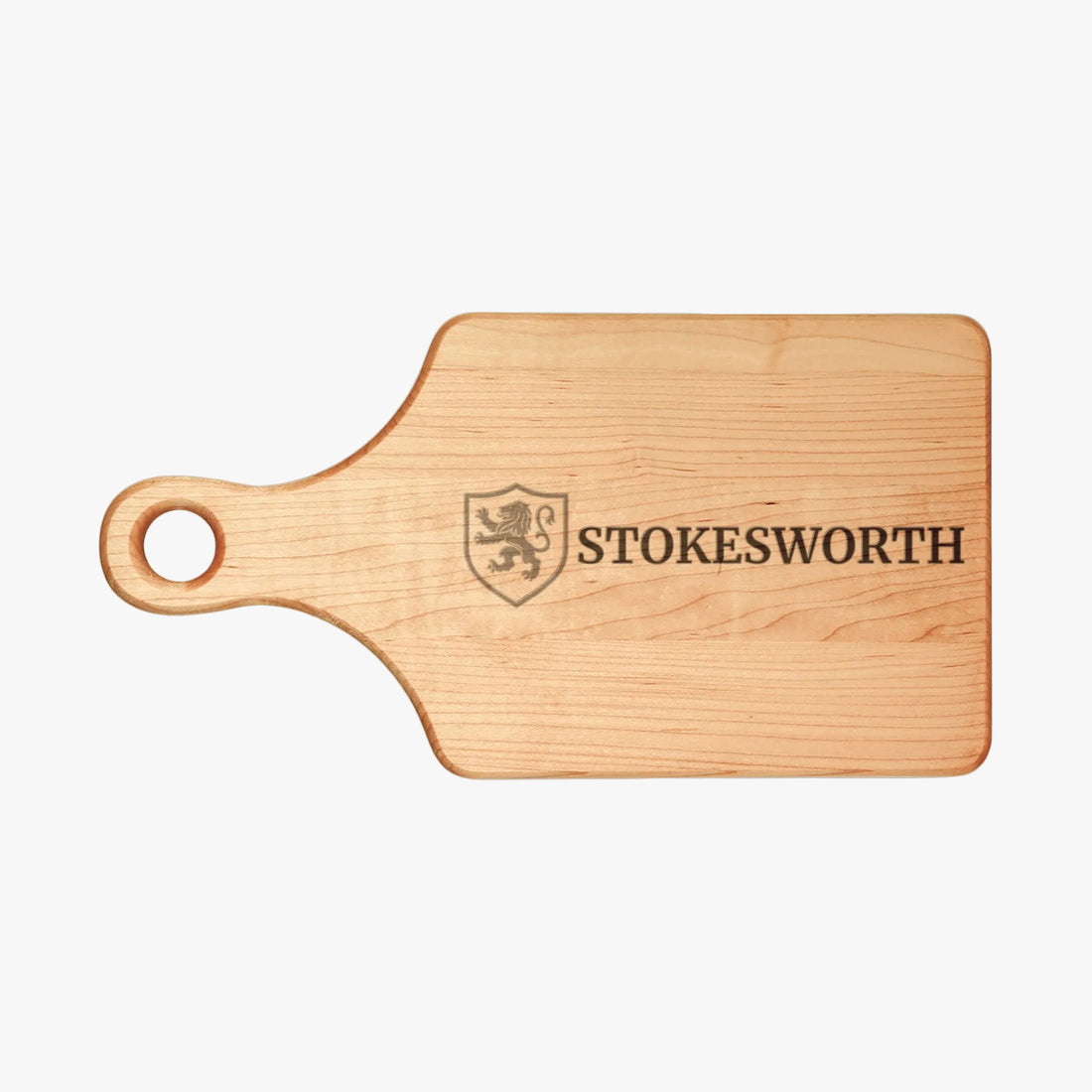 A rectangular wooden cutting board with a rounded handle and a hole for hanging, featuring a dark engraved shield crest and the word 'STOKESWORTH' on a plain white background.